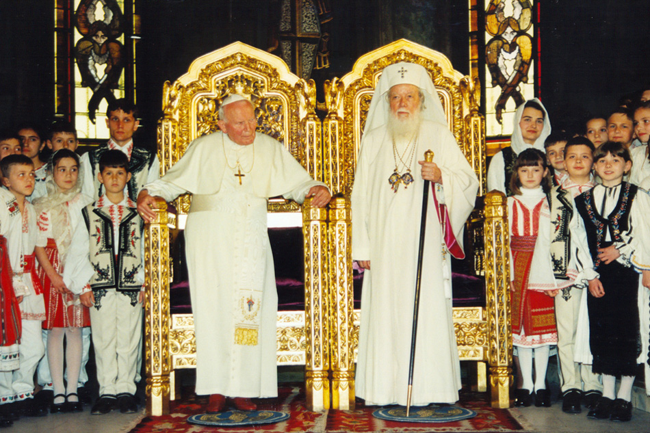 Nous voyons sur cette photo Jean-Paul II avec le patriarche schismatique Teoctist s’asseyant sur des chaires à hauteur égale